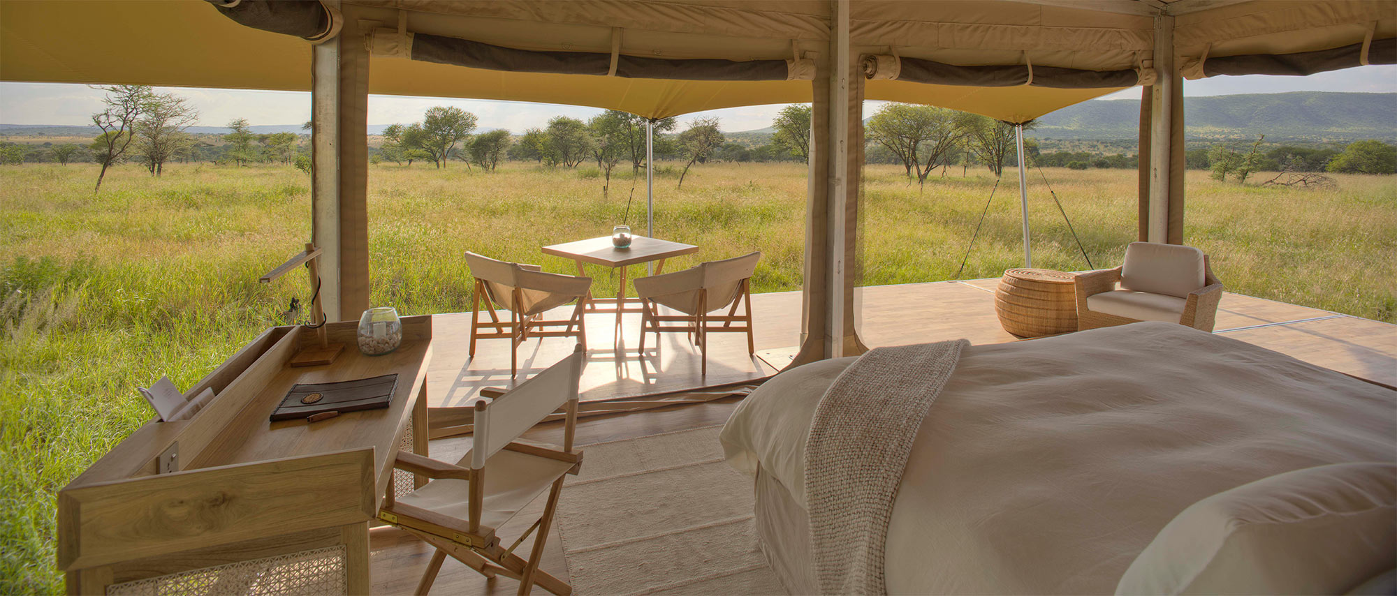 The tent bed overlooking the deck and out onto the Serengeti beyond