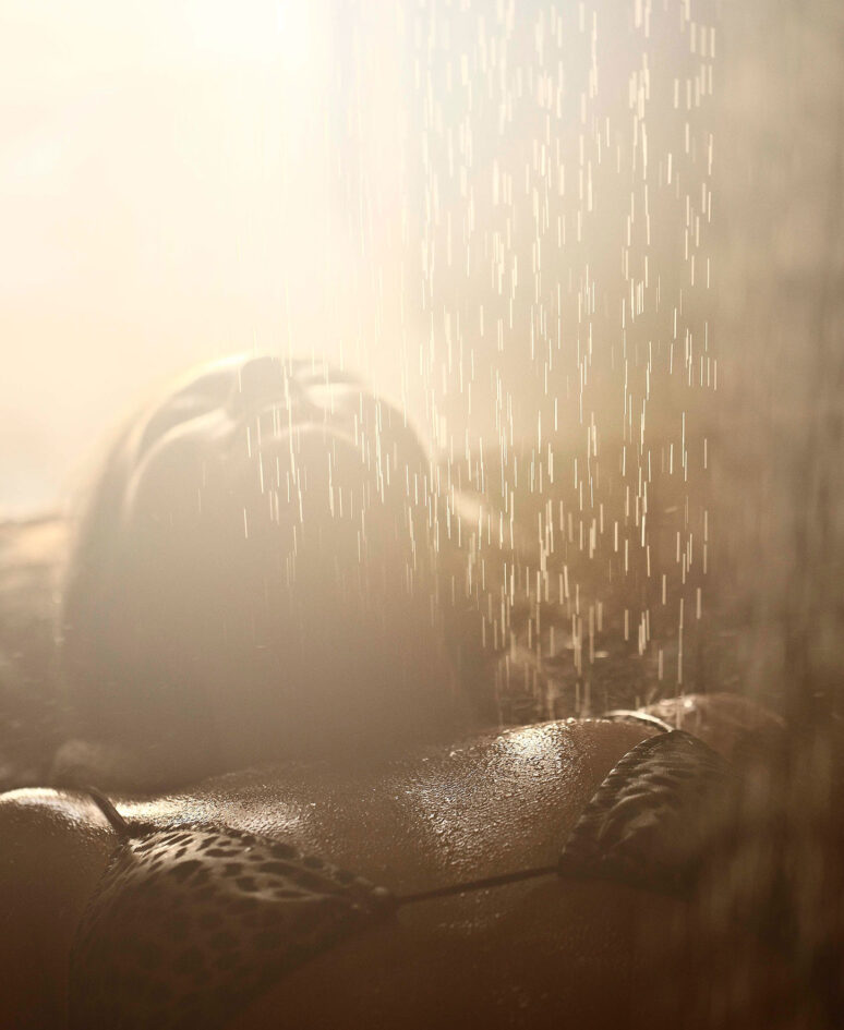 A women laying under a steam of water