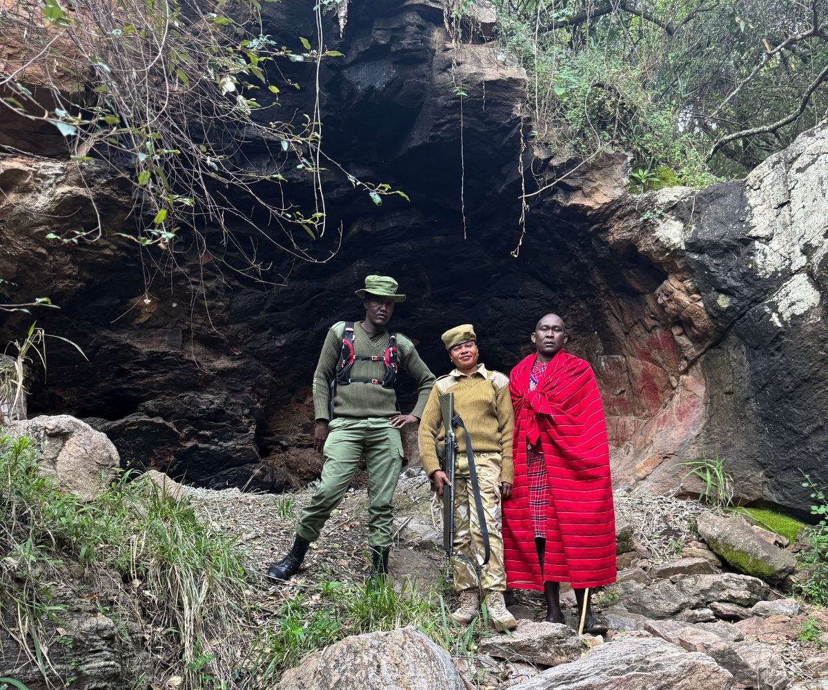 Three guides stand at the entrance to Kakiya Cave