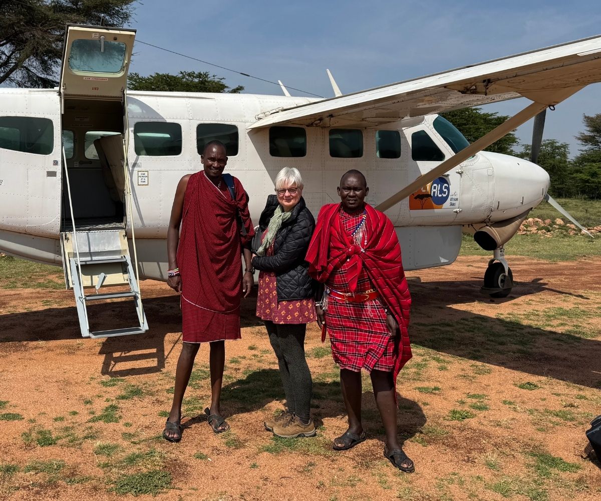 Woman and two Maasai guides boarding a small plane